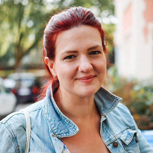 Portraitaufnahme einer lächelnden Frau mit roten Haaren namens Katharina